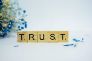 Letras em madeira formando a palavra "trust", confiança em inglês, algo essencial para qualquer marca.